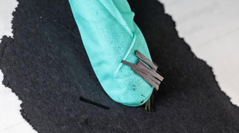 Dry process for more efficient lithium-ion batteries advanced by ORNL breakthrough Small thin shreds are called carbon fiber snippets laying on the finger tip of a blue glove.
