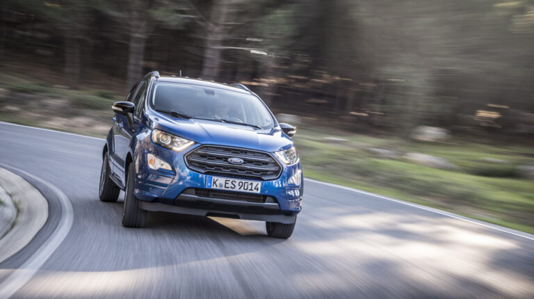 Ford to invest US$5bn in new EV platform, electric pickup and LFP battery production The Ford EcoSport takes a turn on a rural road with the green grass and trees blurred in the background