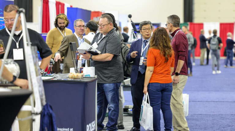 Exhibitors and visitors deep in discussion at Automotive Testing Expo.