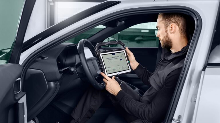 A vehicle engineer uses Mahle's TechPro 2 tool in the driving seat of a test vehicle.