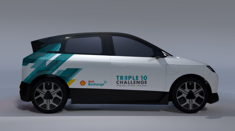 Side on profile promo pic of the Triple 10 Challenge EV concept vehicle from shell. It is a grey hatchback with green and yellow lettering and branding.