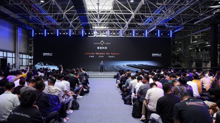InfiMotion Technology hosted a technology showcase in Wuxi on July 16. Automotive industry professionals sit in rows in a large room with a display screen in front of them and InfiMotion staff on a stage.