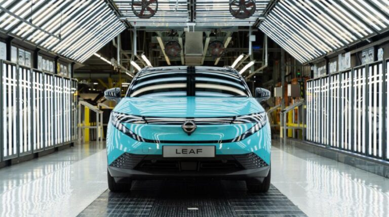 A turquoise Nissan Leaf in a laboratory-styled showroom.